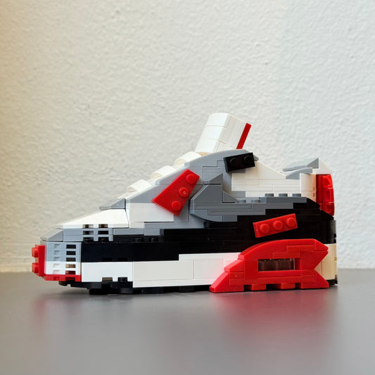 Build your Grail. De unieke bouwset om jouw favoriete sneaker in Lego blokjes na te bouwen. Wordt geleverd met instructieboekje (via QR-code), bouwsteentjes en een klein zwart schoenendoosje. Dit is de variant: Nike Air Max 90 Infrared.